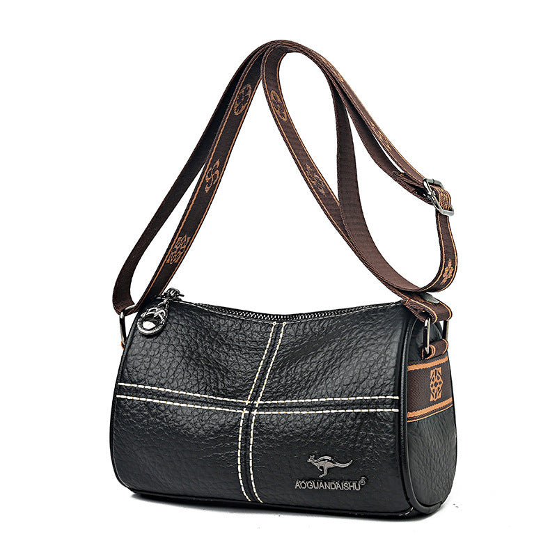 Black handbag with brown strap and visible brand logo on a white background