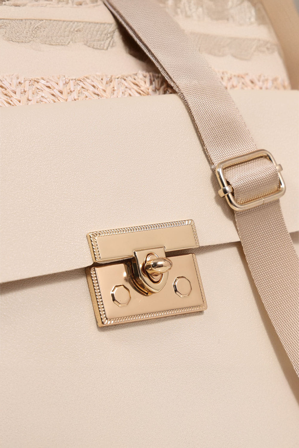 Close-up of a beige handbag with a gold clasp on a matching background