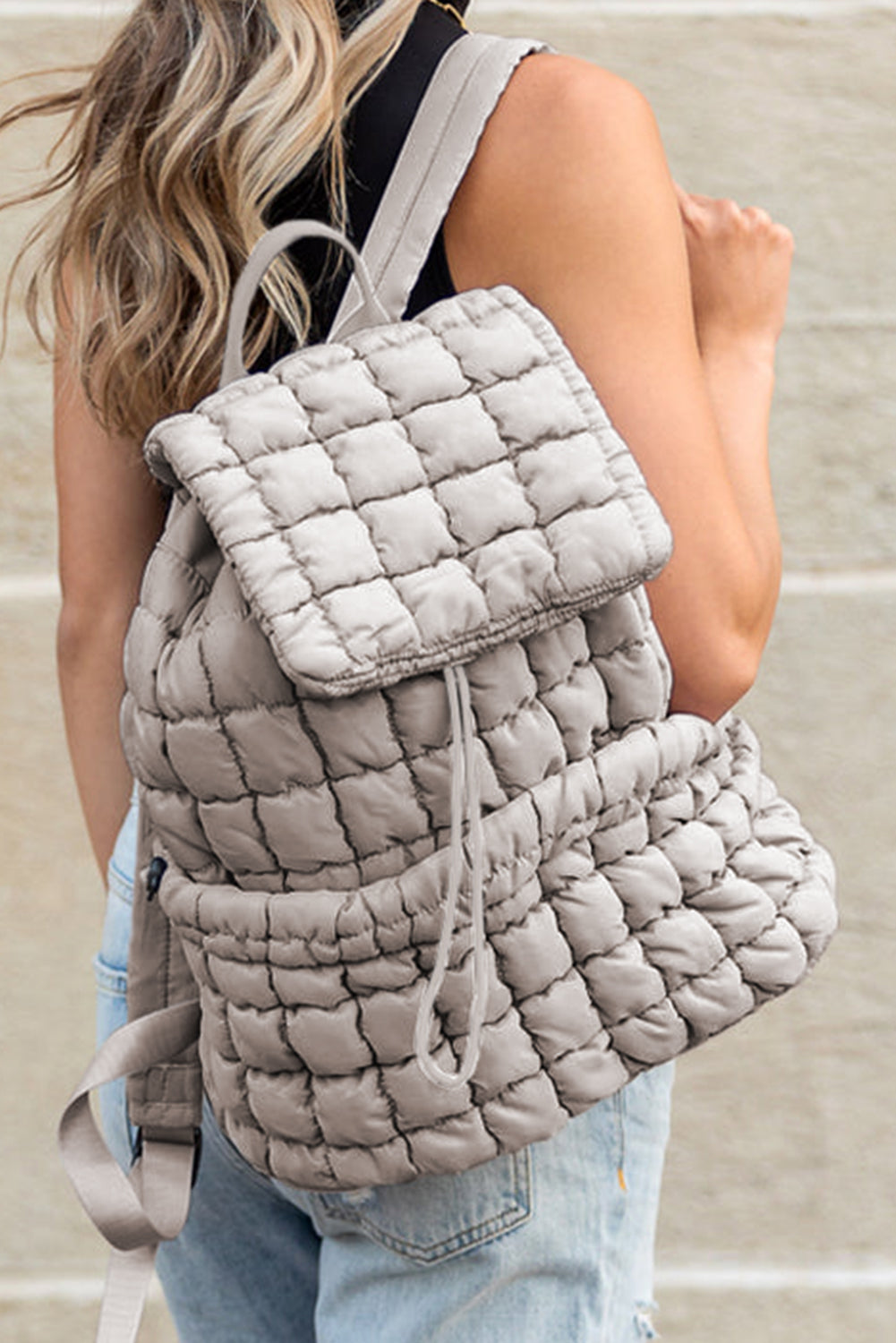 Model wearing a Chic medium grey Quilted Puffer Flap Backpack across the back