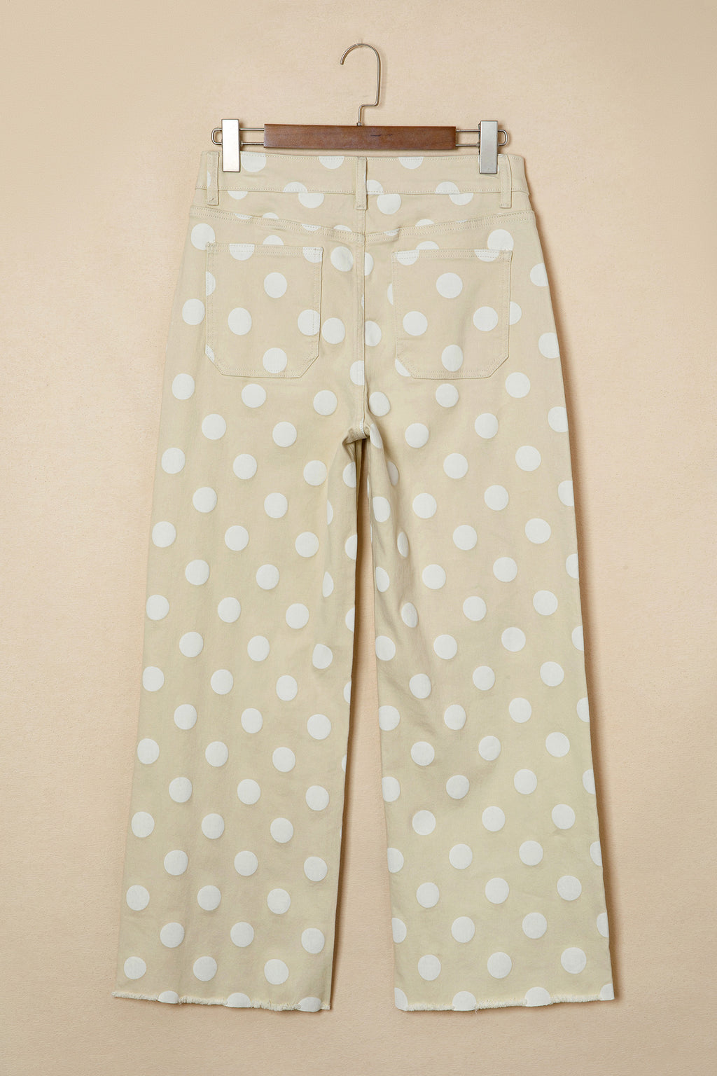 Polka dot pants back view on a beige background  