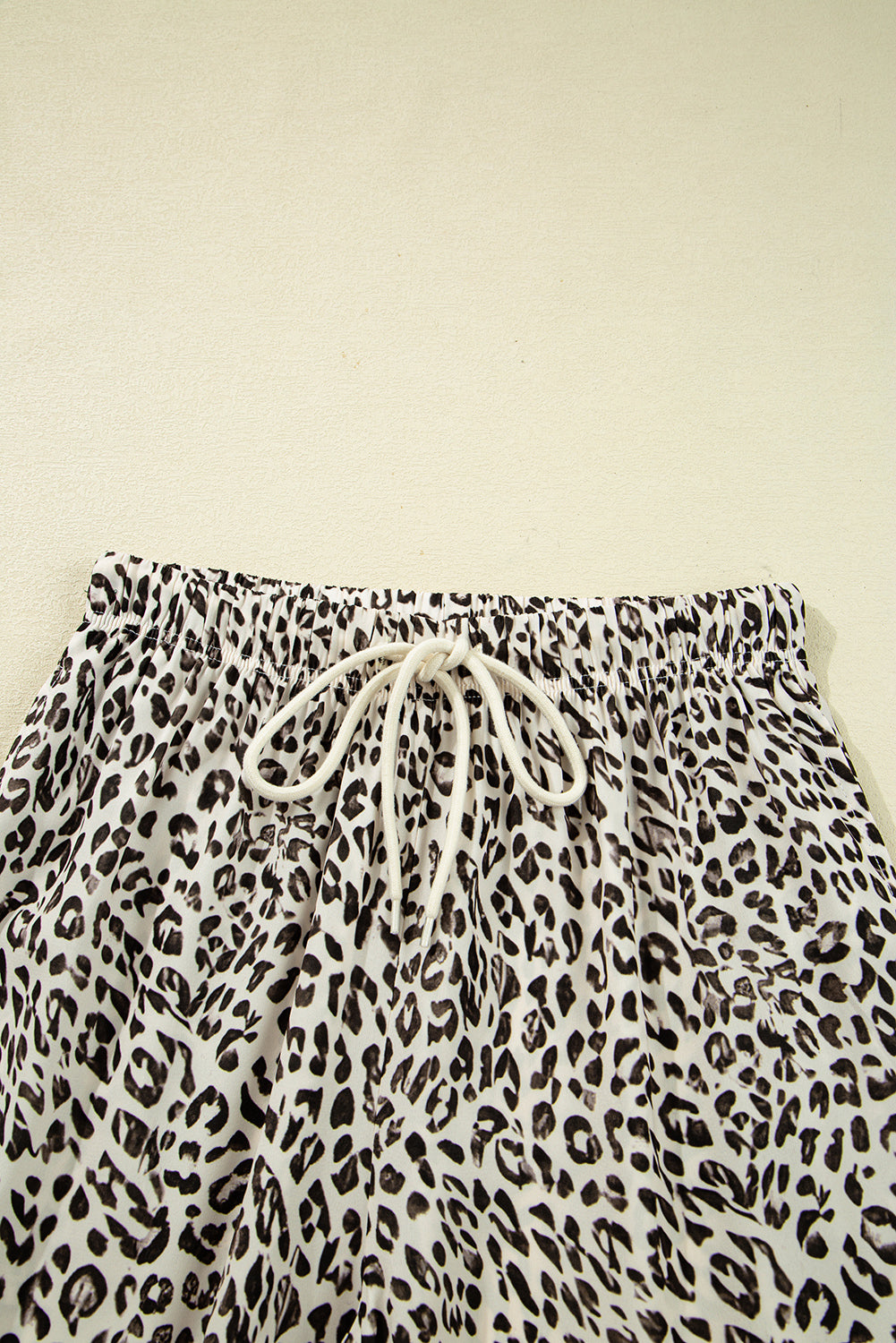 Leopard print shorts with drawstring on a beige background