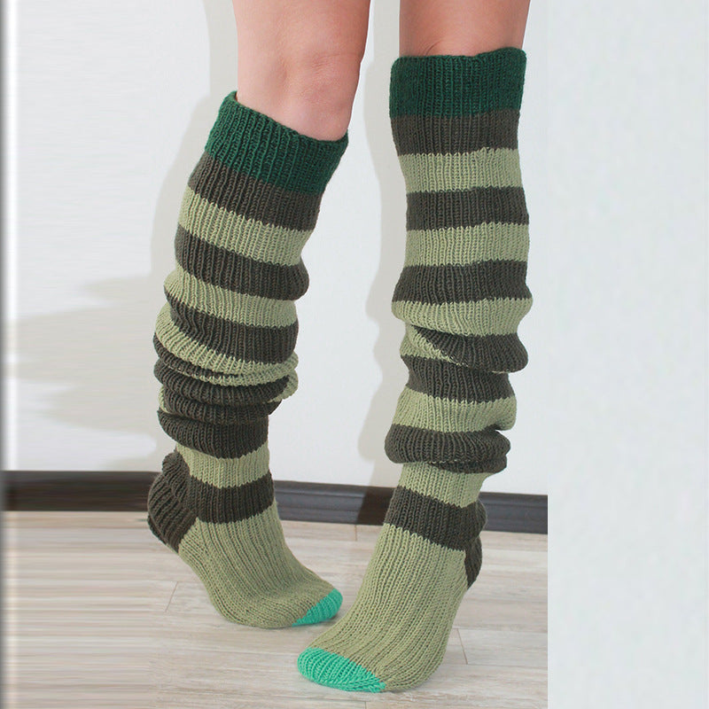 Green and brown striped socks worn by a person on a light background