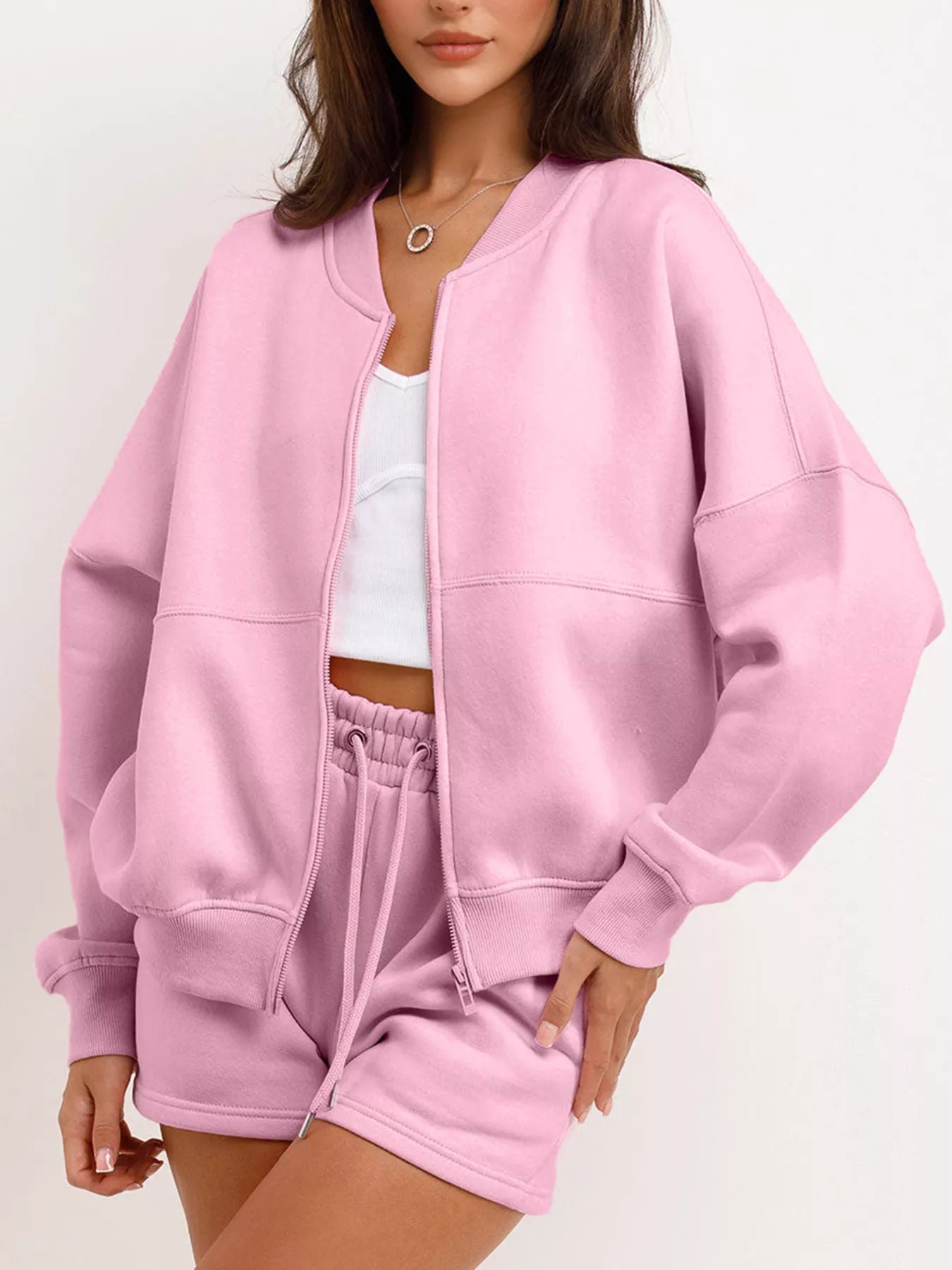 Person wearing a pink tracksuit on a white background