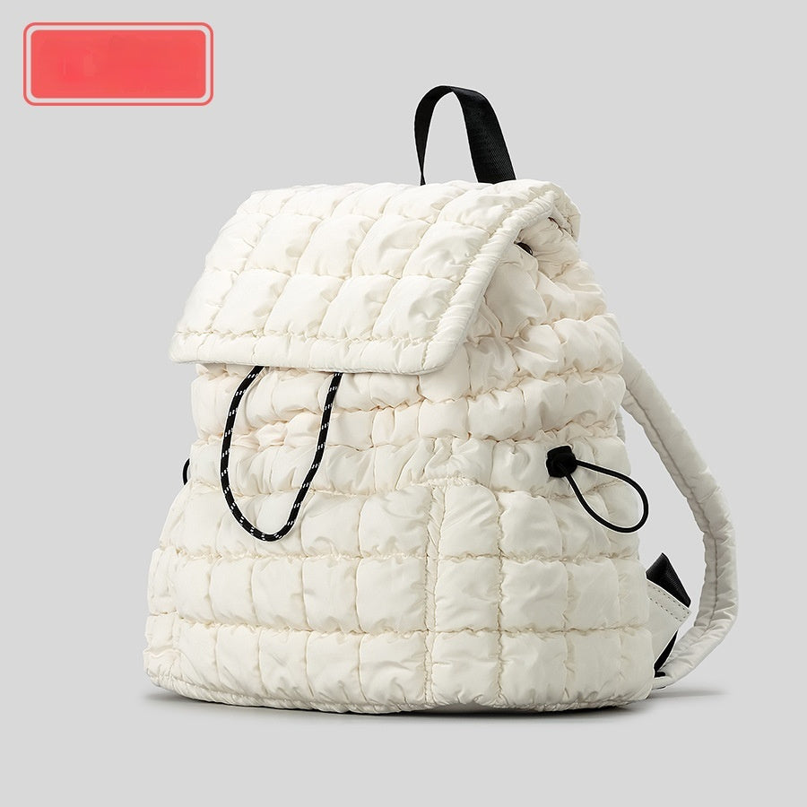 White quilted backpack with black straps on a gray background