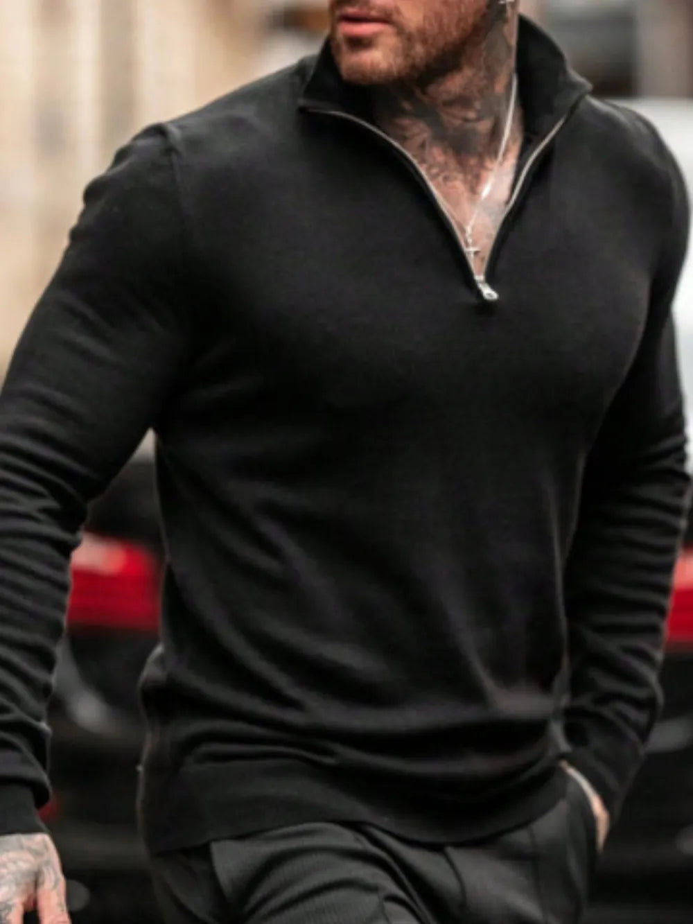 Man wearing a black quarter zip long sleeve knit top  