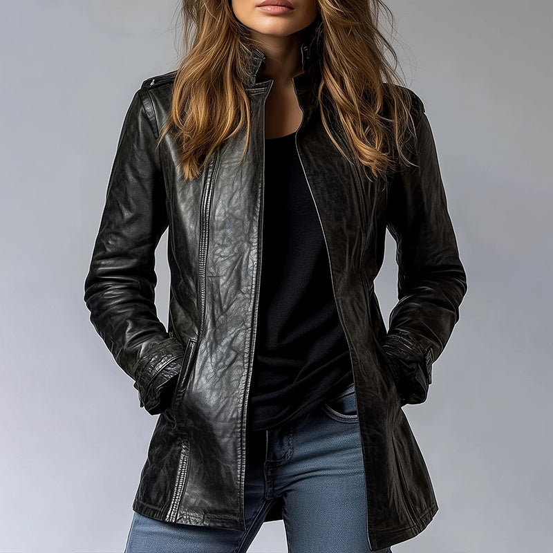 Person wearing a black leather jacket and blue jeans against a gray background