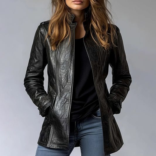 Person wearing a black leather jacket and blue jeans against a gray background