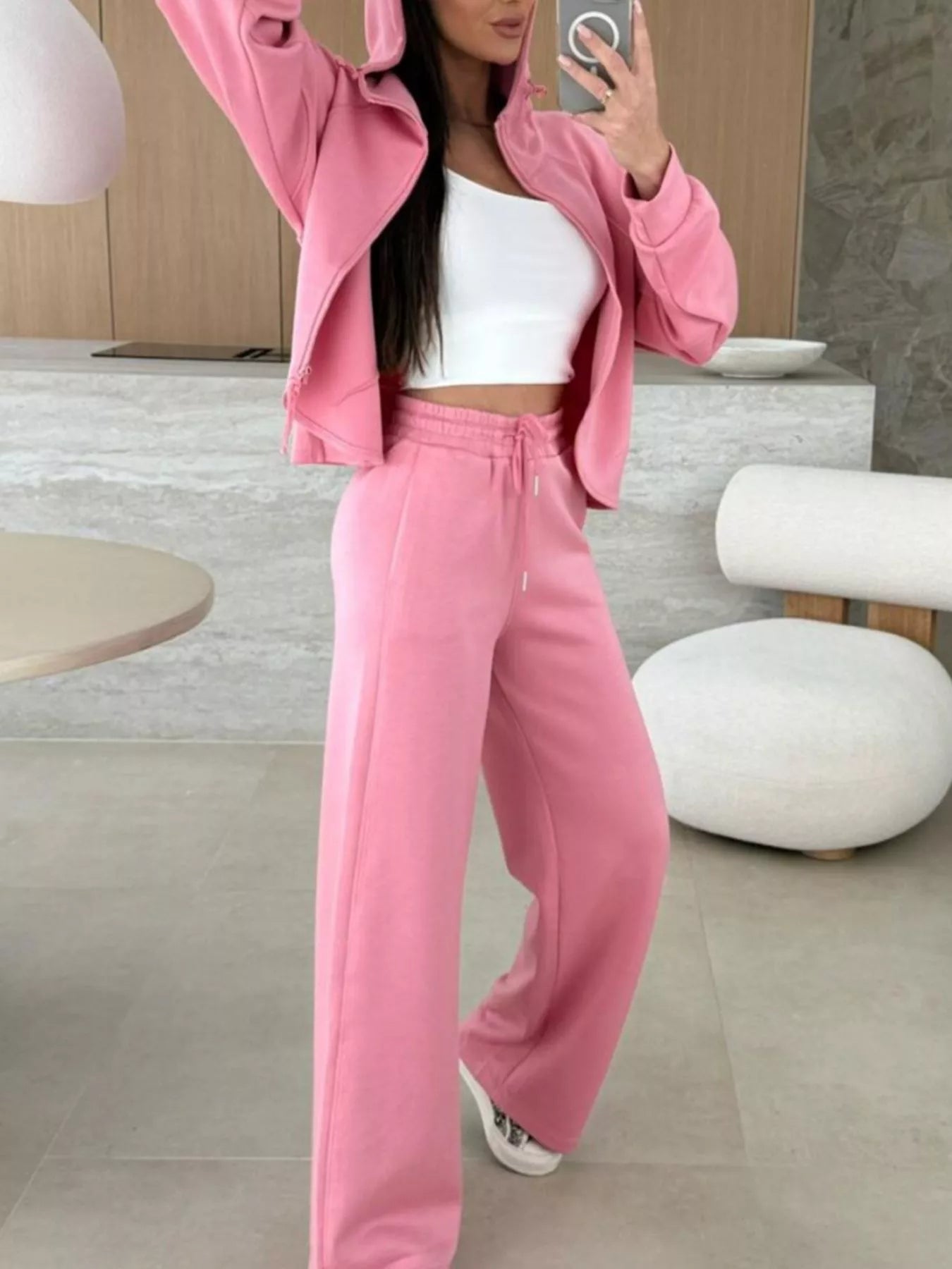 Person wearing a pink tracksuit in a modern kitchen setting