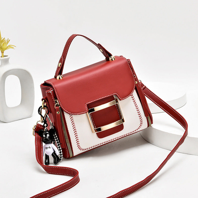 Red and white handbag with a gold buckle on a white background