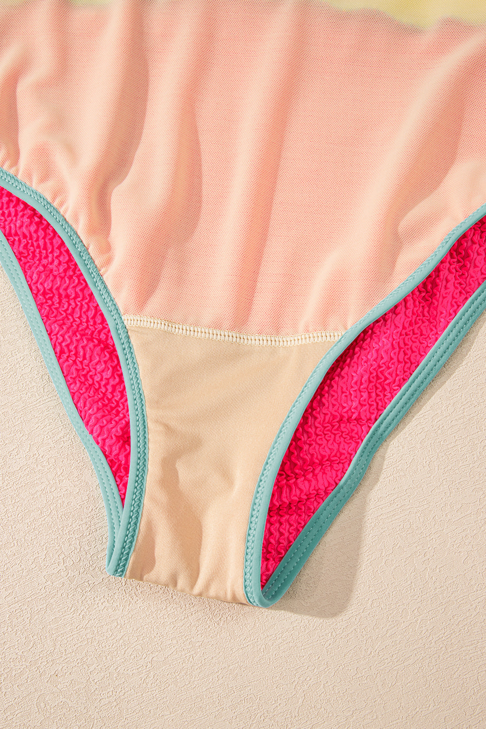 Close-up of a pink and beige garment with a textured border.