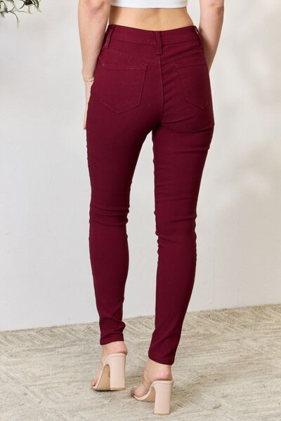 Back view of a Model wearing a pair of Dark Wine Ladies YMI Hyperstretch Mid-Rise Skinny Jeans