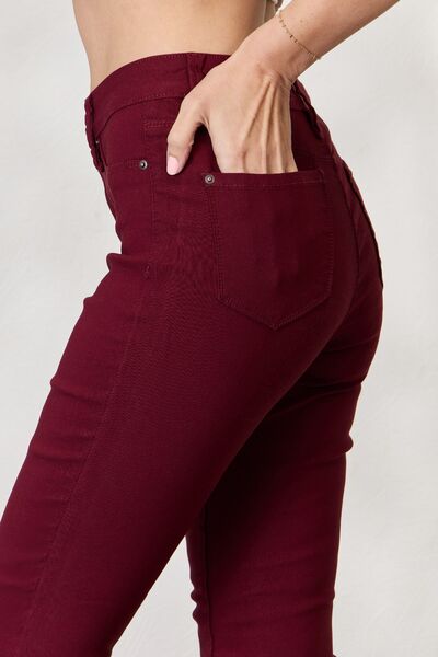 Close up side view of a Model wearing a pair of Dark Wine Ladies YMI Hyperstretch Mid-Rise Skinny Jeans