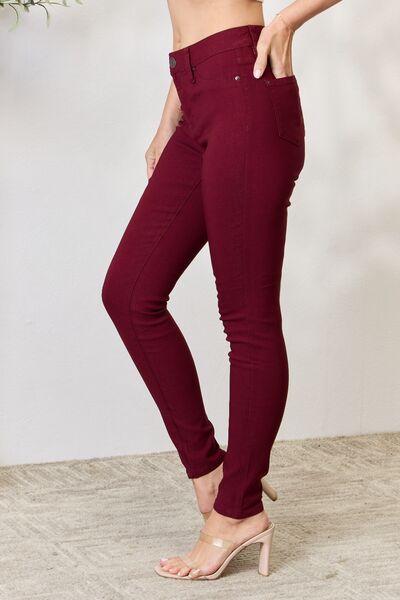 Side view of a Model wearing a pair of Dark Wine Ladies YMI Hyperstretch Mid-Rise Skinny Jeans