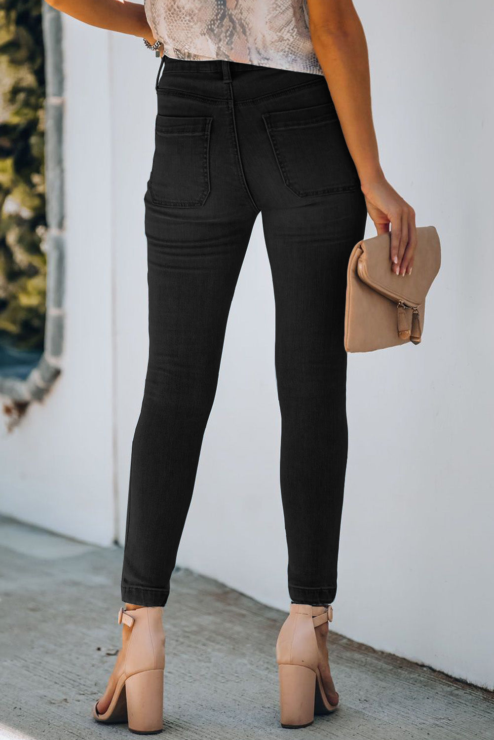 The back view of a model wearing a pair of Women's Black Chic Button Fly Skinny Jeans