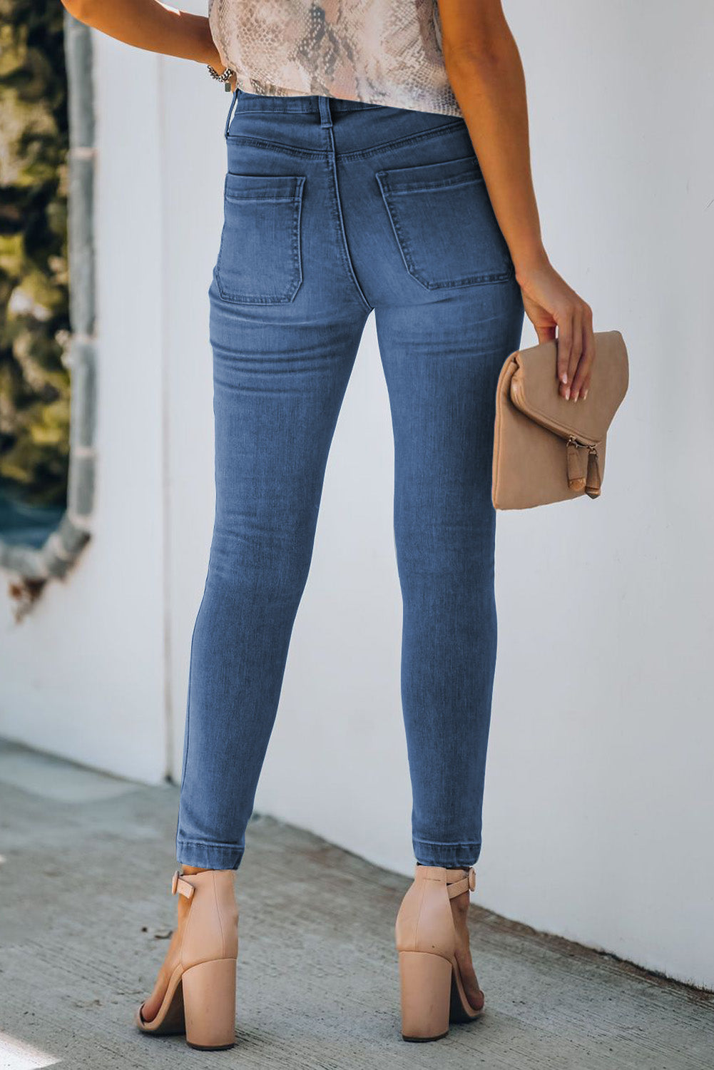 The back view of a model wearing a pair of Women's Blue Chic Button Fly Skinny Jeans