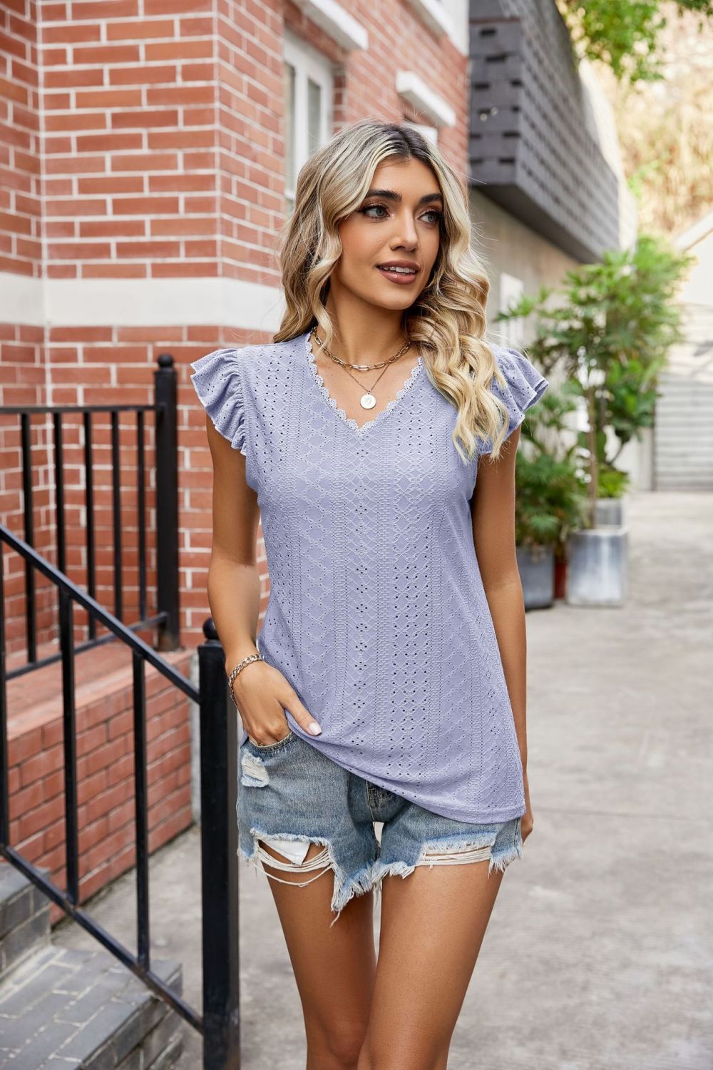 Model wearing a Lavender Ladies Eyelet Flutter Sleeve Scalloped V-Neck Top