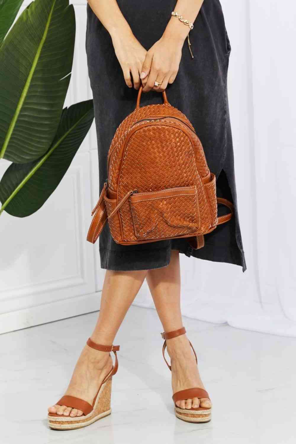 Model holding SHOMICO Certainly Chic Faux Leather Woven Backpack by carry handle