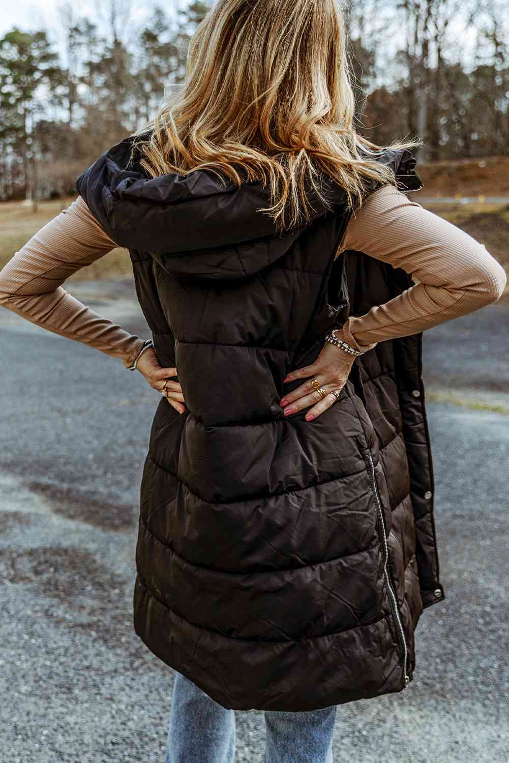 Back view a model wearing a Black Women's Posh Sleeveless Longline Hooded Puffer Vest