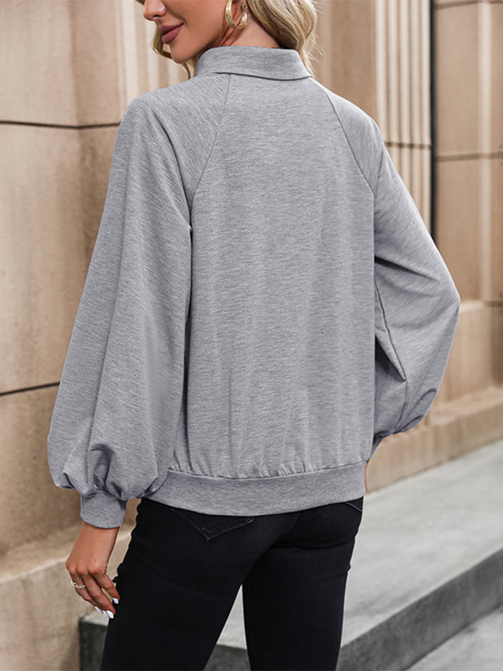 A back view of a model wearing a Cloudy Blue Women's Collared Front Pocket Raglan Sleeve Blouse