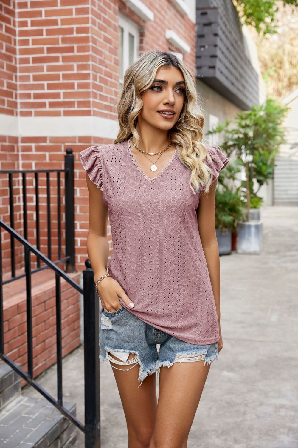 Model wearing a Moonlit Mauve Ladies Eyelet Flutter Sleeve Scalloped V-Neck Top